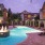 swimming pool with in-pool fountain lit up at dusk